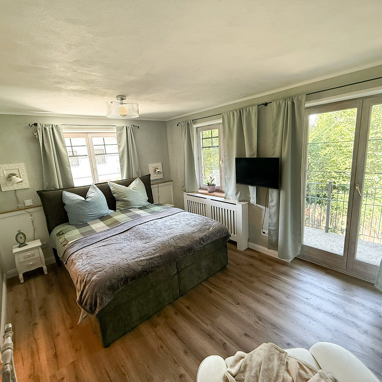Großes Bett in grünem Zimmer